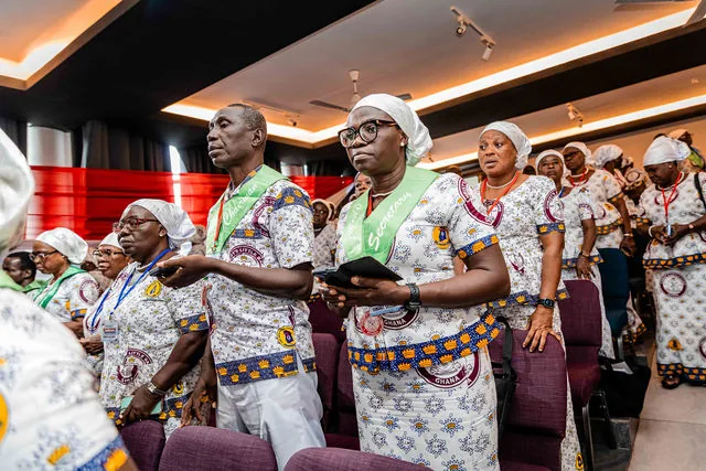 Members standing together with hymn books during worship at the diocesan conference.